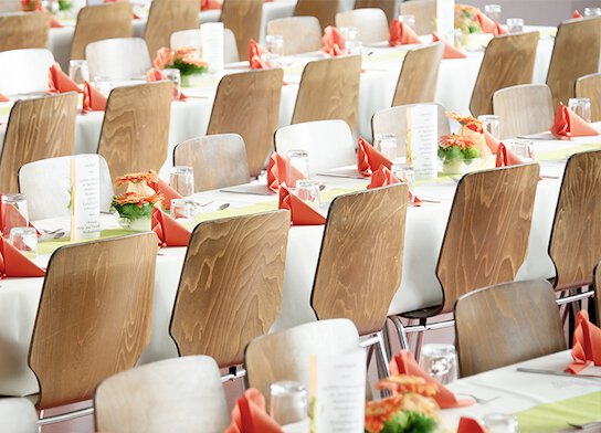 Table and chairs set for meal at an event.