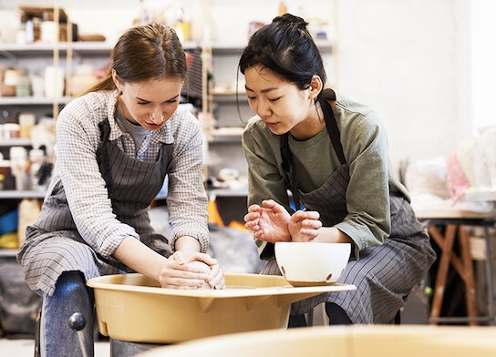 Femmes utilisant le tour de potier au cours de poterie.